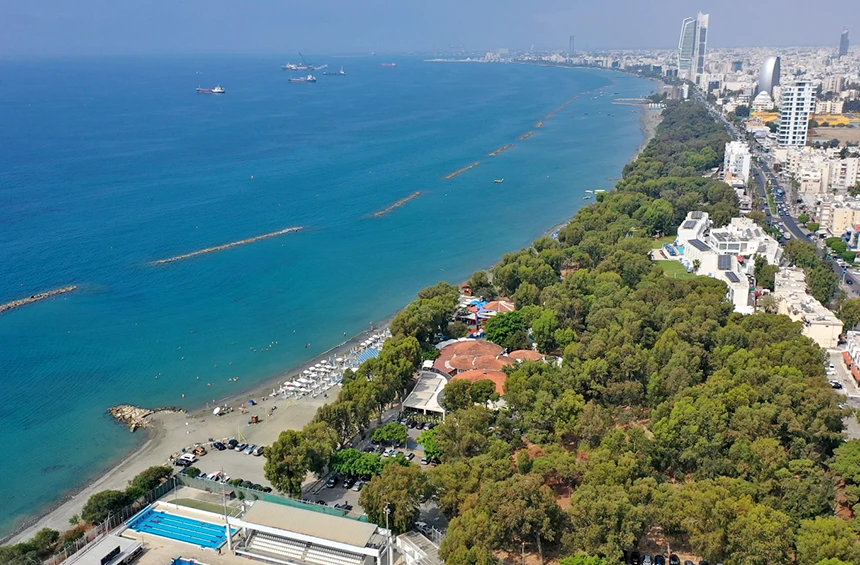  A popular coastal area lined with trees and clear water, offering a relaxed and scenic view from the yacht.